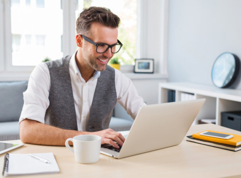 Young happy designer working on laptop from home - freelance con